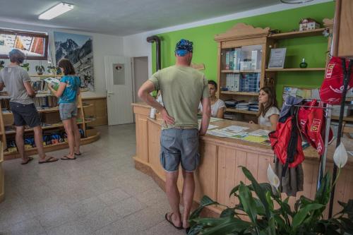 a man standing at a counter in a store at Sarca Lodge Val Rendena in Dare