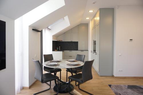 a kitchen and dining room with a table and chairs at Modern New-Build Apt, managed by RentiFor in Klaipėda
