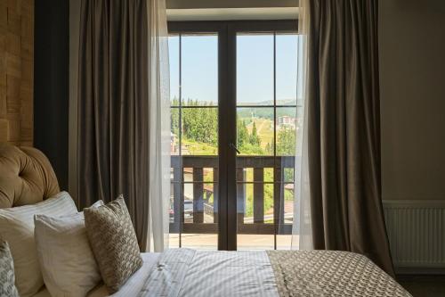 a bedroom with a bed and a sliding glass door at Greitser Elit Chalet in Bukovel