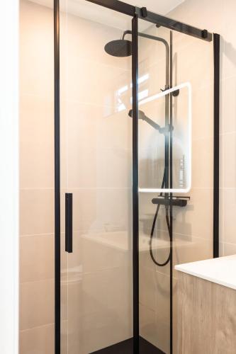 a shower with a glass door in a bathroom at Square 32 Luxury Shipping container in Knockcloghrim