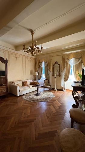 a large living room with a bed and a chandelier at Palazzo Lari Sarzana - Historic Boutique Rooms in Sarzana