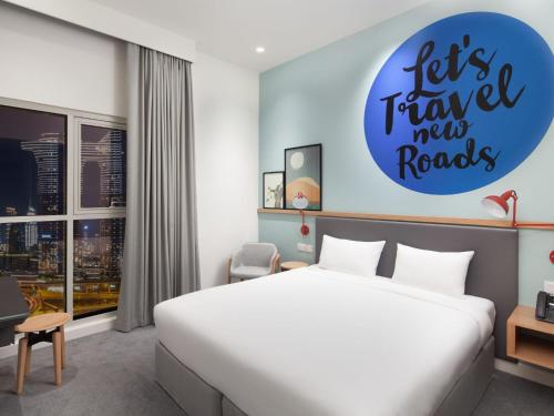 a bedroom with a bed and a sign that reads lets travel my roads at Rove City Walk in Dubai