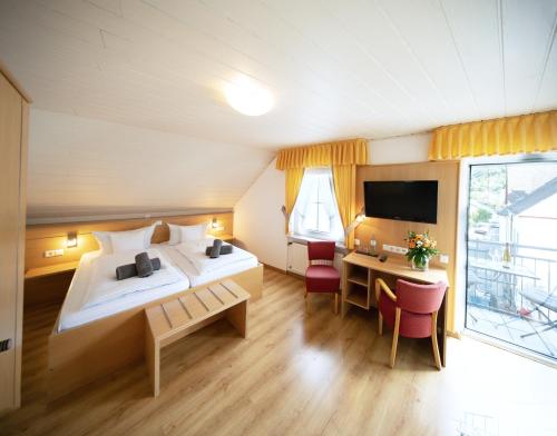 a hotel room with a large bed and a desk at Hotel zum Moselstrand in Briedern
