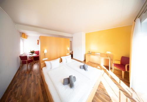 a hotel room with a white bed in a room at Hotel zum Moselstrand in Briedern