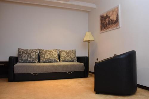 a living room with a couch and a lamp at Guest House Vila Lujza in Palić
