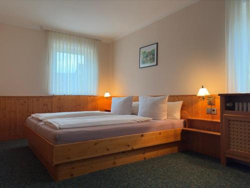 a bedroom with a large wooden bed in a room at Hotel Rebstock in Rust