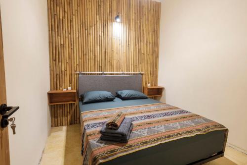 a bedroom with a bed with blue pillows on it at Kokomo Yogyakarta in Yogyakarta