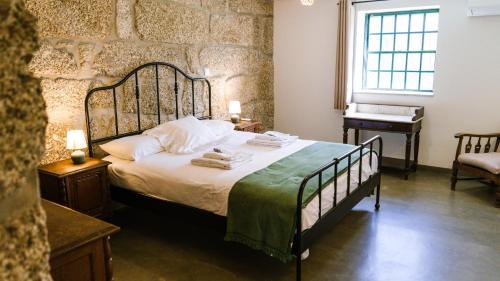 a bedroom with a bed with towels and a piano at Casa do Outeiro in Vila Meã