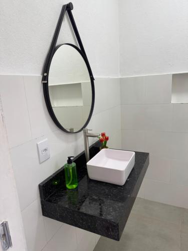 a bathroom with a sink and a mirror on a counter at Chalé portal da serra in Serra do Cipo