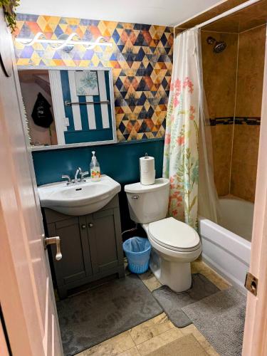 a bathroom with a toilet and a sink and a tub at Spacious room near subway & shops in Toronto