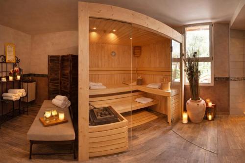 a room with a tub with a table and a table sidx sidx at Logis Hotel Le Lac in Embrun