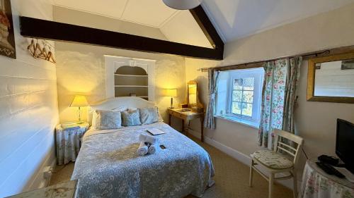 a bedroom with a bed with a teddy bear on it at Bickleigh Castle - A Majestic Devon Estate for Exclusive Gatherings in Winkleigh