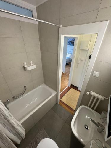 a bathroom with a tub and a toilet and a sink at Cosy studio in Lausanne Flon in Lausanne