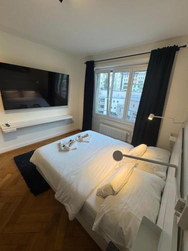 a bedroom with a large white bed and a large window at Cosy studio in Lausanne Flon in Lausanne
