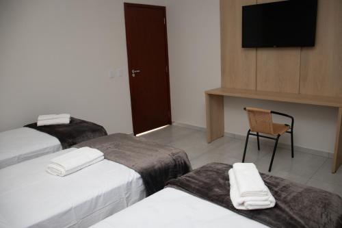 Hotel Tibério Filho tesisinde bir odada yatak veya yataklar