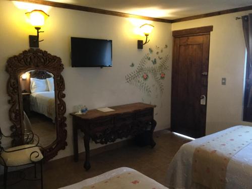 a hotel room with a mirror and a bed and a mirror at Hotel Grand Maria in San Cristóbal de Las Casas