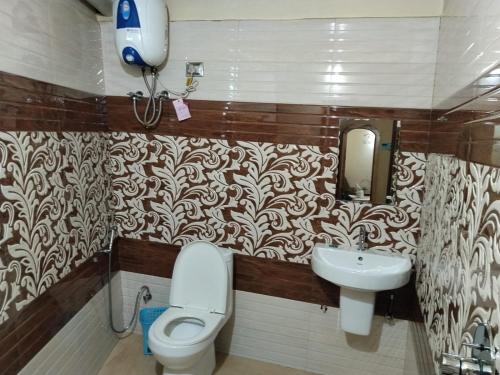 a bathroom with a toilet and a sink at Pradhan Hotel Mirik Lake Side in Mirik