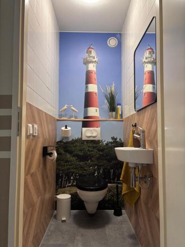 a bathroom with two lighthouse paintings on the wall at Amelander Paradijs Ferienwohnung in Buren
