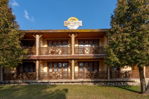 an exterior view of a large building with a balcony at Hotel Ranč u Edyho in Námestovo