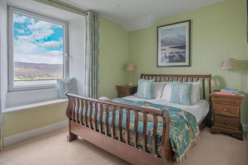 a bedroom with a bed and a window at Tanderra Coniston in Coniston