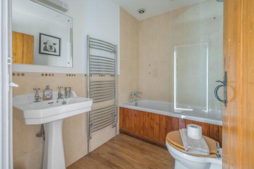 a bathroom with a sink and a tub and a toilet at Tanderra Coniston in Coniston