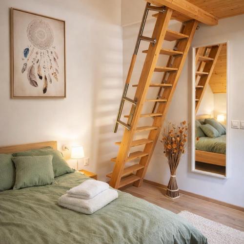 a bedroom with a bed and a wooden staircase at Hiša Lunna - Apartments in a Forest Paradise in Vitanje
