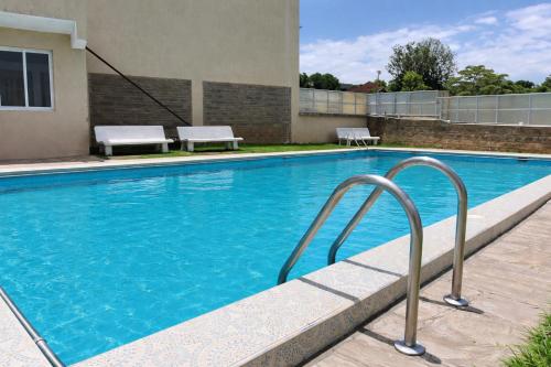 a swimming pool with blue water in front of a building at SarafuDeluxe in Nakuru