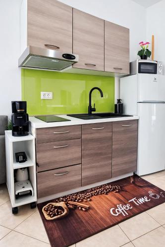 a kitchen with a sink and a white refrigerator at Apartmani Tomislav in Krk