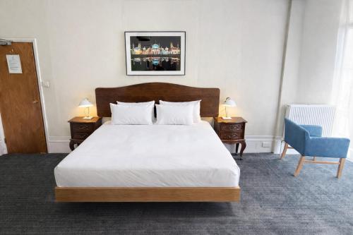 a bedroom with a large bed and a blue chair at Brighton House in Brighton & Hove