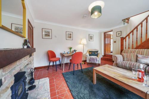 a living room with a couch and a fireplace at Channel Cottage in Wells next the Sea