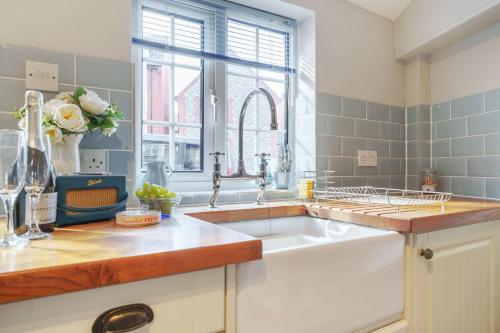 a kitchen with a sink and a window at Channel Cottage in Wells next the Sea