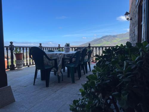 a table and chairs on a balcony with a view of the ocean at Casa Rural La Xana in Piloña