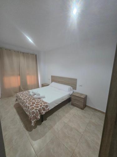 a bedroom with a bed and a light on the ceiling at Las Jarcias 2C in Moncófar