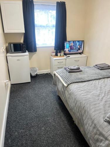 a bedroom with a bed and a television in it at Rugby House in Birmingham