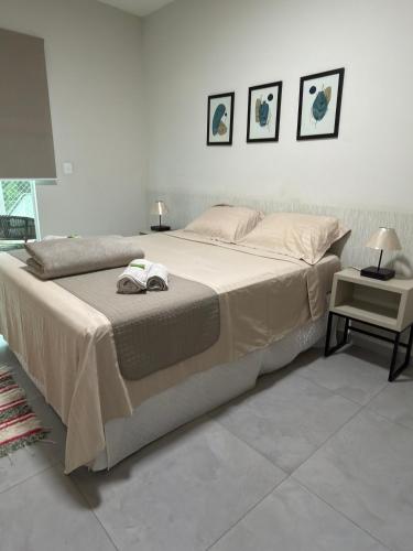 a large bed in a bedroom with two pictures on the wall at Apartamento Completo localizado no centro in Matias Barbosa