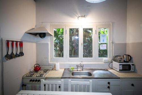 a kitchen with a sink and a stove and windows at Casona Don Roque in Salta