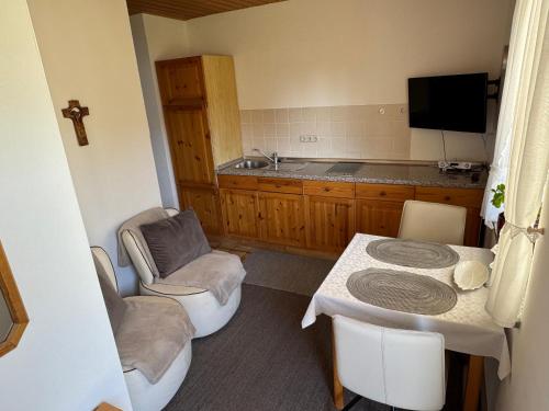 a kitchen with a table and chairs and a sink at Ferienwohnungen Gmeiner in Bad Endorf