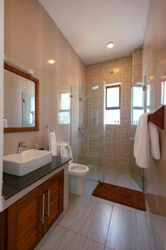 a bathroom with a sink and a toilet and a shower at Spacious 3 bedroom ensuite villa Pazuri vipingo in Mombasa