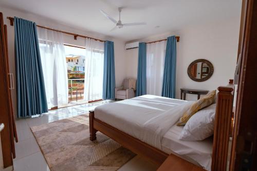 a bedroom with a bed and a large window at Spacious 3 bedroom ensuite villa Pazuri vipingo in Mombasa