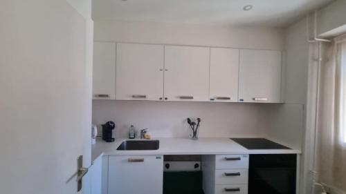 a kitchen with white cabinets and a sink at Zimmer In Luzern in Arni Alp