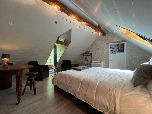 a bedroom with a bed and a desk in a attic at Gîte climatisé avec jacuzzi privé & terrasse - jusqu'à 7 pers entre Blois et Amboise in Chouzy-sur-Cisse