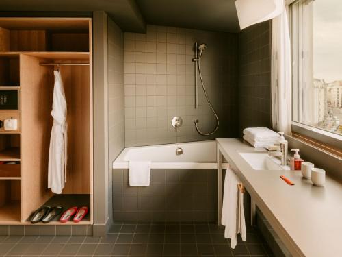 a bathroom with a tub and a sink at Casa Camper Berlin in Berlin