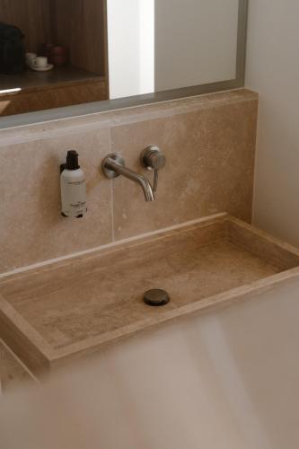 a bathroom sink with a faucet and a mirror at Piatti beach suites in Zandvoort