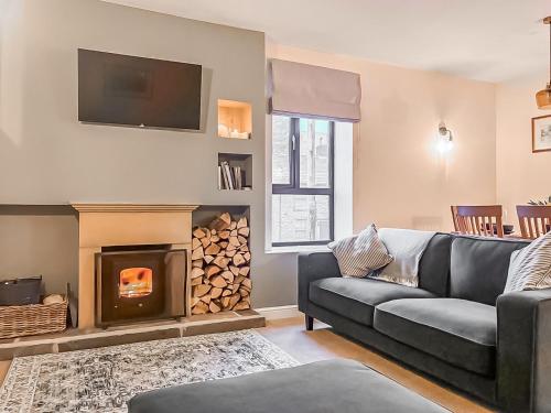 a living room with a couch and a fireplace at The Coach House in Kettlewell