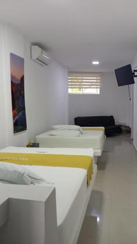 a room with four beds in a room at Hotel Puerto Triunfo in Doradal