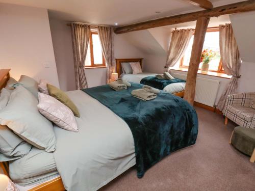 a large bedroom with two beds and two windows at Boundcliffe Farm in Allerston