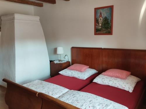 two beds in a room with a red bed sidx sidx sidx at Fótos Vendégház in Tiszaderzs