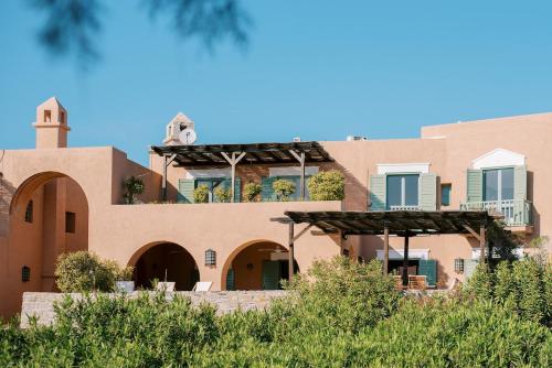 a building with a clock on the top of it at Beachfront Majestic Villa in Liaropá
