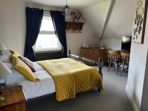a bedroom with a bed with a yellow blanket at Overdale Guesthouse and Free Parking in Whitby