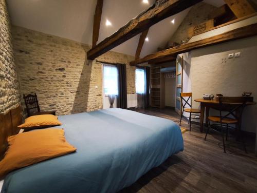 a bedroom with a large bed and a table at Omaha Secret Normandy Cottages in Saint-Laurent-sur-Mer
